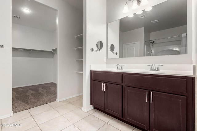 full bathroom with a spacious closet, walk in shower, visible vents, and a sink