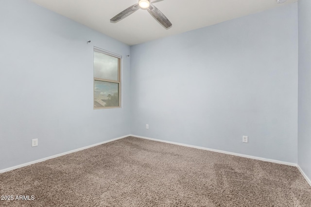 spare room featuring a ceiling fan, carpet, and baseboards