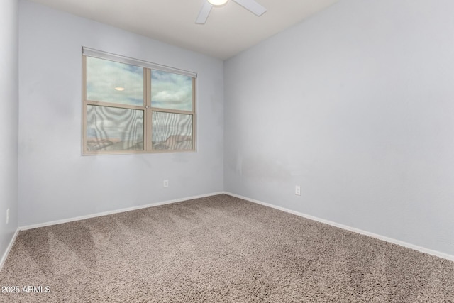 carpeted spare room featuring baseboards and ceiling fan