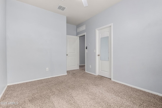 spare room with baseboards, visible vents, carpet floors, and ceiling fan