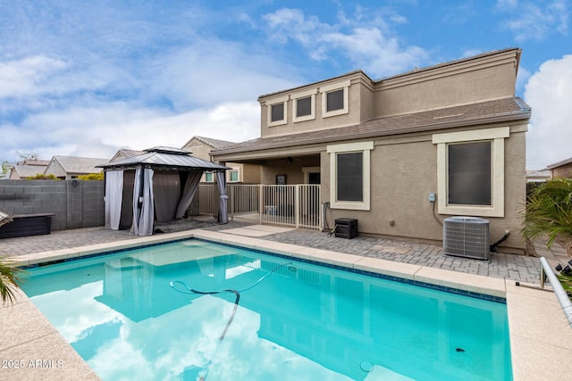 view of pool featuring a patio, a fenced in pool, central AC unit, fence, and a gazebo