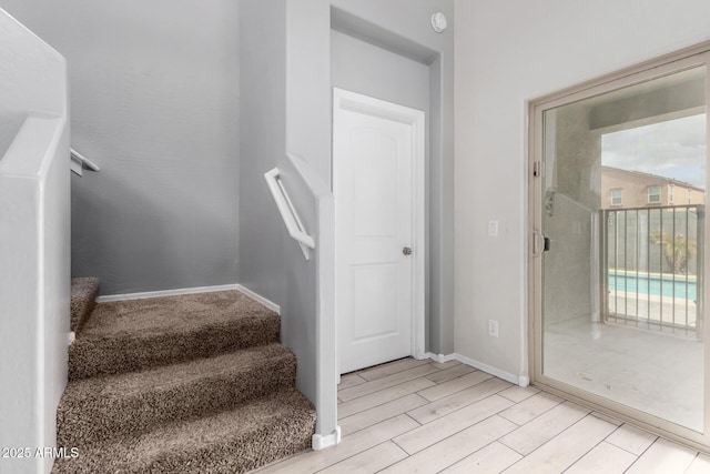 stairs featuring wood finished floors and baseboards