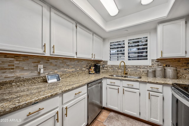 kitchen with light stone counters, white cabinetry, a sink, dishwasher, and tasteful backsplash