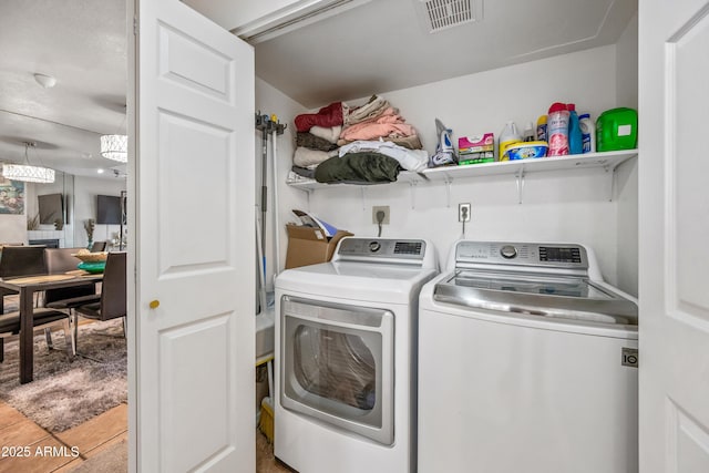 laundry area with washer and dryer, laundry area, visible vents, and tile patterned flooring