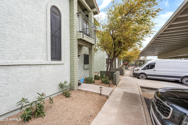 view of side of property with a balcony and stucco siding