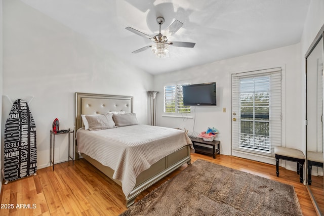 bedroom featuring a ceiling fan, access to exterior, and wood finished floors