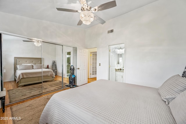 bedroom with wood finished floors, visible vents, a closet, and ceiling fan