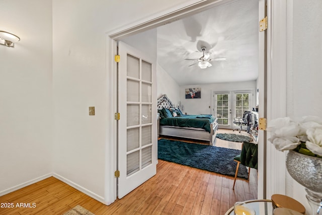 bedroom featuring light wood-style flooring, a ceiling fan, access to outside, french doors, and baseboards