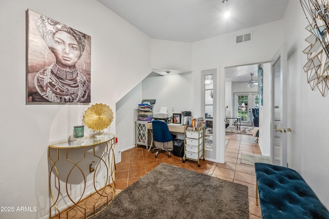 tiled office space with visible vents, baseboards, and a ceiling fan