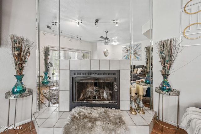 living area featuring a tiled fireplace, a ceiling fan, and tile patterned flooring