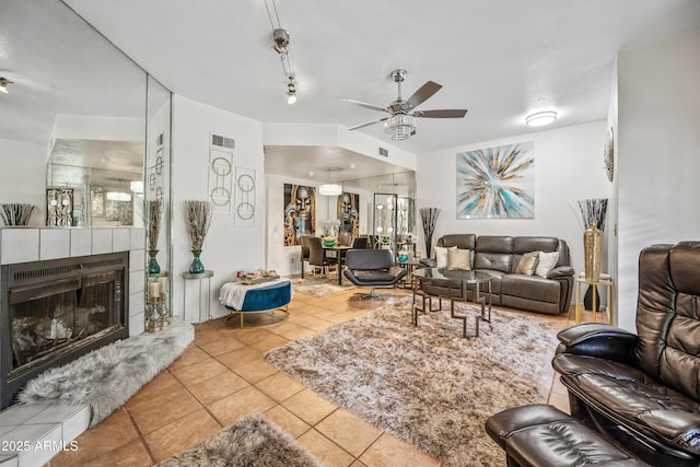 living area featuring tile patterned floors, visible vents, a fireplace, and ceiling fan