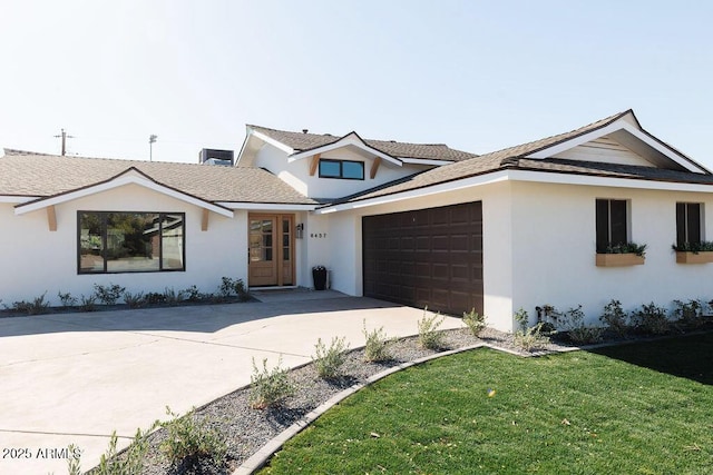 single story home with a garage and a front lawn