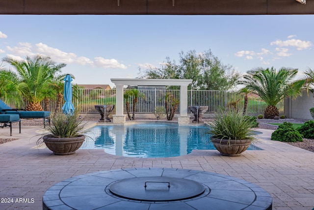 view of pool with pool water feature, an outdoor fire pit, and a patio area