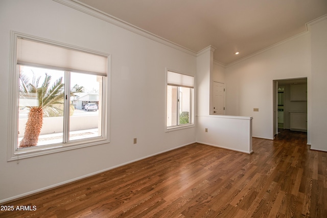 empty room with ornamental molding, dark wood-style flooring, and baseboards