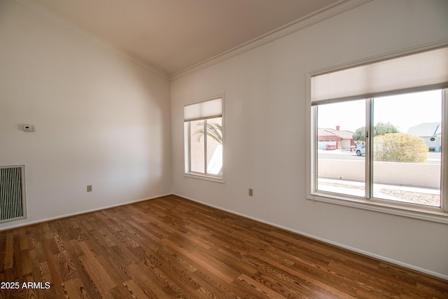 unfurnished room with dark wood-type flooring, visible vents, crown molding, and baseboards