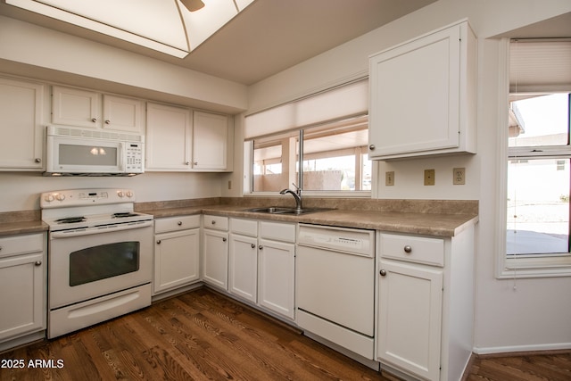 kitchen featuring white appliances, a sink, white cabinetry, a ceiling fan, and dark wood finished floors