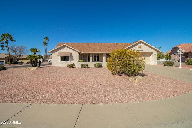 ranch-style house with a garage, concrete driveway, and stucco siding