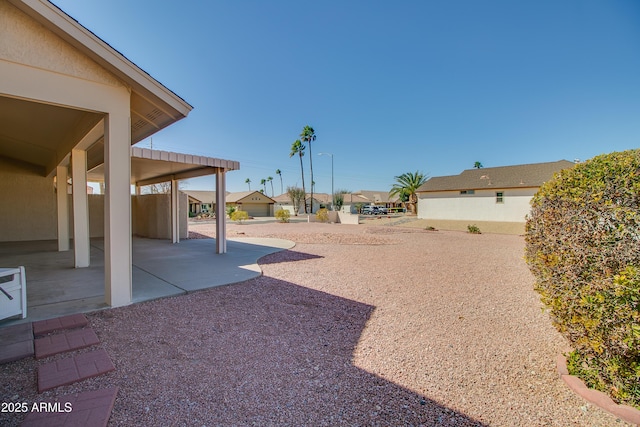 view of yard featuring a residential view and a patio