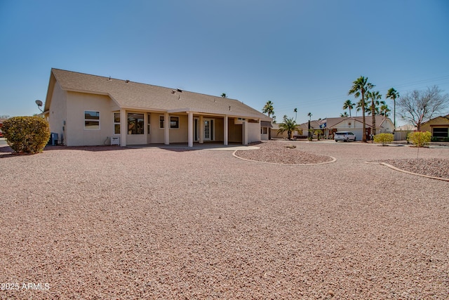 rear view of house featuring central air condition unit, a patio area, and stucco siding