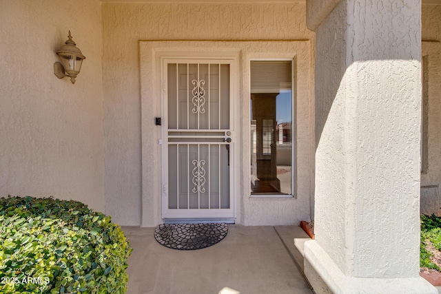 view of exterior entry with stucco siding