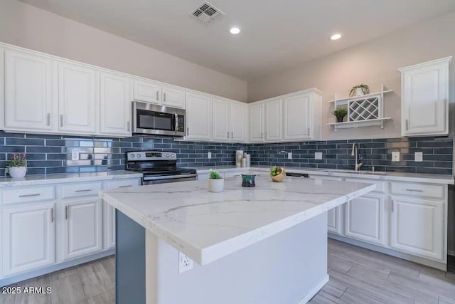 29891 N Desert Angel Dr, San Tan Valley, AZ 85143 - kitchen featuring stainless steel appliances, a sink, open shelves, white cabinetry, and a center island