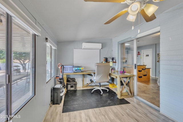 office area featuring wood finished floors, ceiling fan, and a wall unit AC