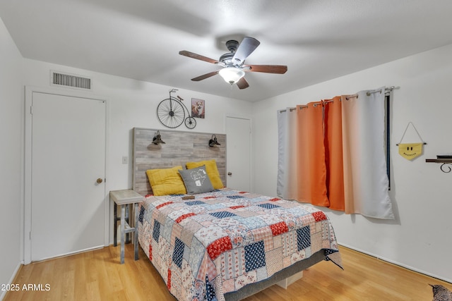 bedroom featuring visible vents, ceiling fan, and wood finished floors
