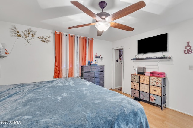 bedroom featuring baseboards, a ceiling fan, and wood finished floors