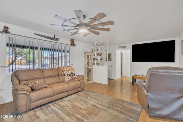 living room featuring visible vents, ceiling fan, and wood finished floors