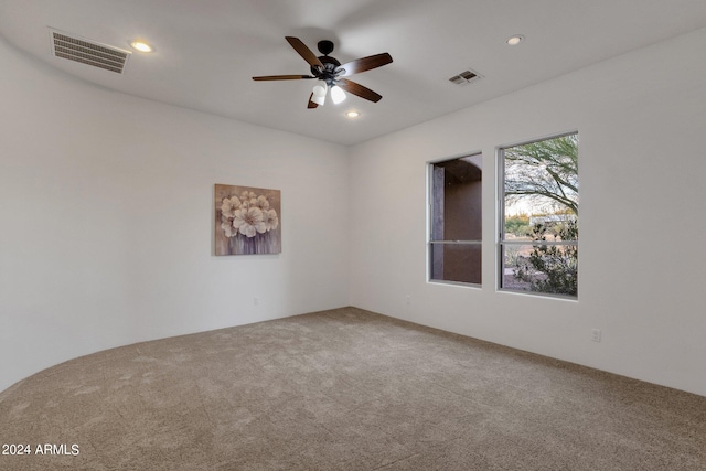 empty room with ceiling fan and carpet flooring