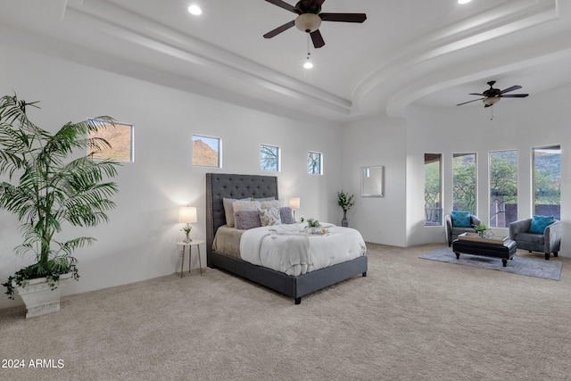 bedroom with ceiling fan, carpet, and a high ceiling