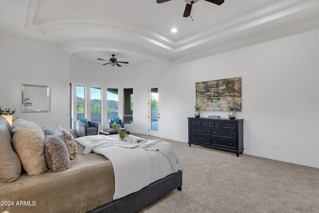 bedroom with a raised ceiling, carpet flooring, access to outside, and ceiling fan