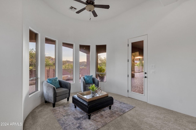 sitting room with light carpet, a towering ceiling, and ceiling fan