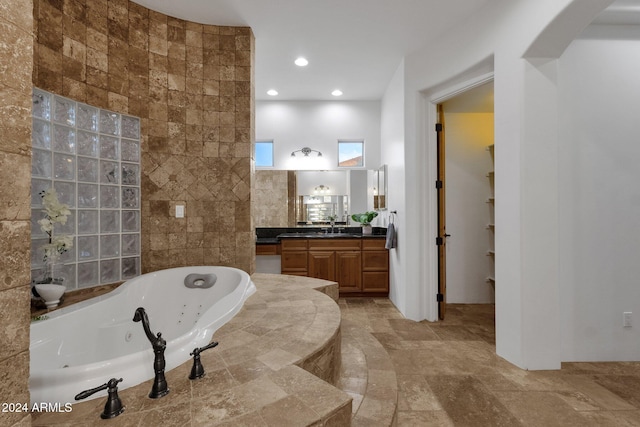 bathroom featuring vanity, tile walls, and a bathing tub