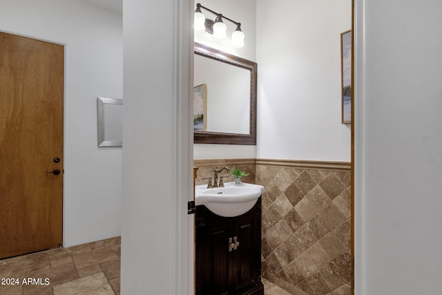 bathroom featuring vanity and tile walls