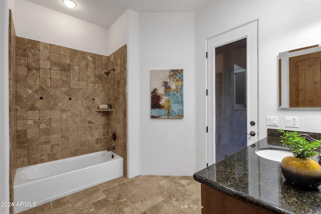 bathroom featuring tiled shower / bath and vanity