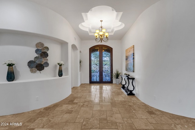 foyer entrance featuring french doors and a chandelier