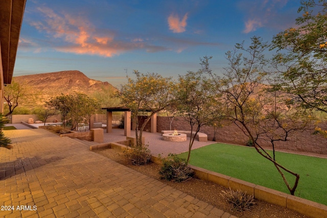 view of property's community with a patio, a mountain view, and an outdoor fire pit