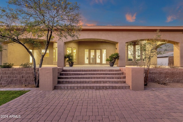 exterior entry at dusk featuring french doors