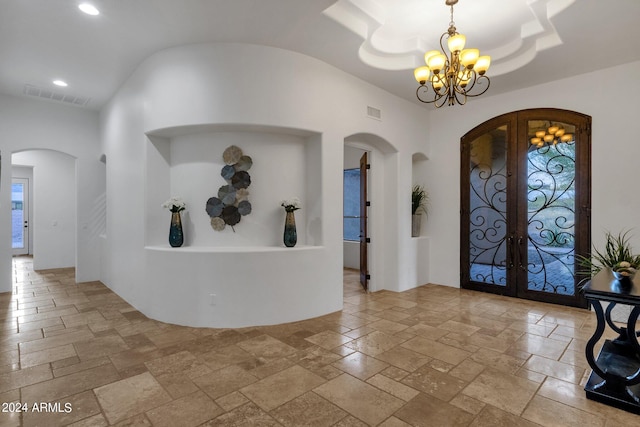 foyer featuring an inviting chandelier and french doors