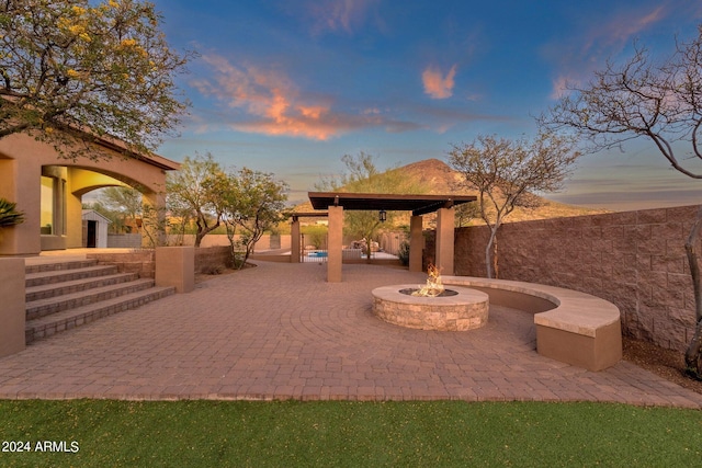 patio terrace at dusk featuring a gazebo and a fire pit