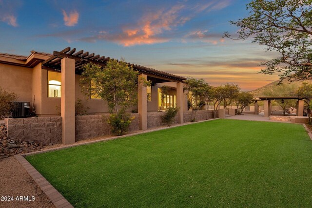 yard at dusk featuring central air condition unit and a patio