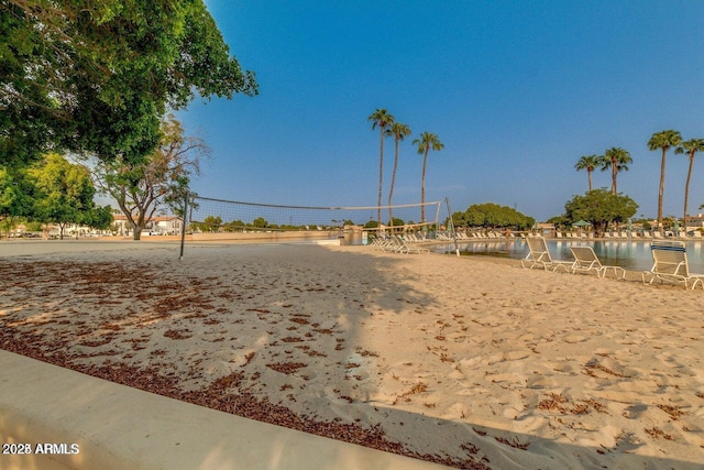 view of home's community with a water view and volleyball court