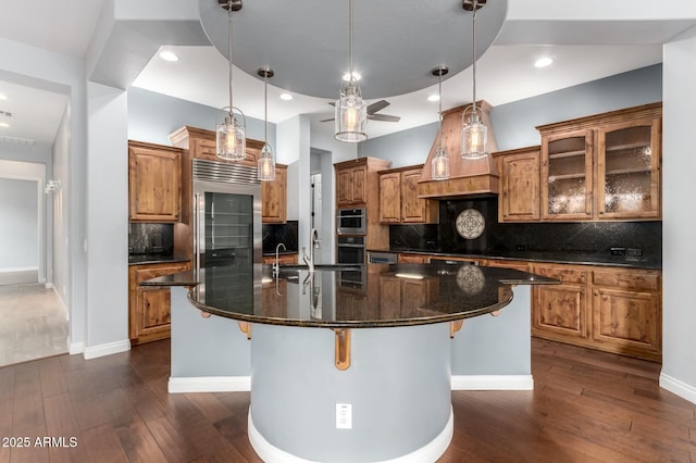 1407 E Artemis Trl, San Tan Valley, AZ 85140 - kitchen featuring brown cabinetry, dark wood finished floors, a sink, stainless steel appliances, and a large island