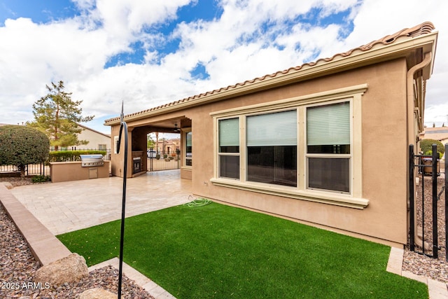 1407 E Artemis Trl, San Tan Valley, AZ 85140 - back of house with stucco siding, a patio, an outdoor kitchen, and fence