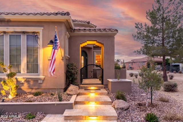 1407 E Artemis Trl, San Tan Valley, AZ 85140 - view of exterior entry with stucco siding, a tile roof, fence, and a gate