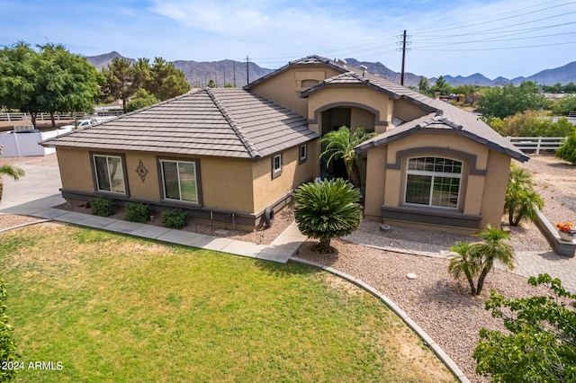 ranch-style house featuring a mountain view and a front lawn