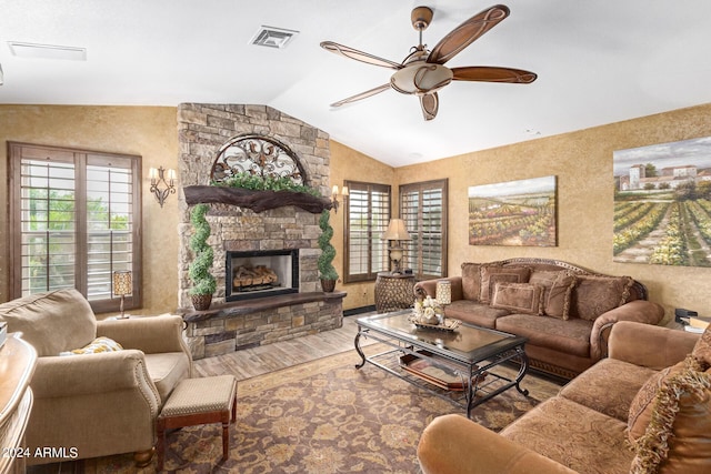 living room featuring hardwood / wood-style floors, ceiling fan, lofted ceiling, and a fireplace