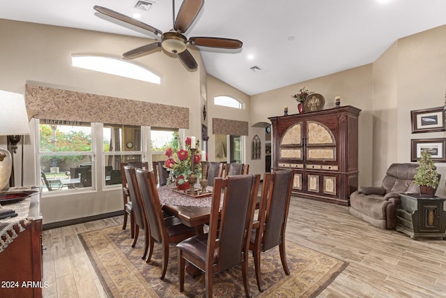 dining space featuring ceiling fan, light wood-type flooring, and high vaulted ceiling