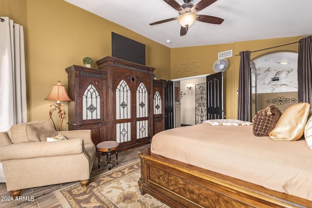 bedroom with ceiling fan, wood-type flooring, and lofted ceiling